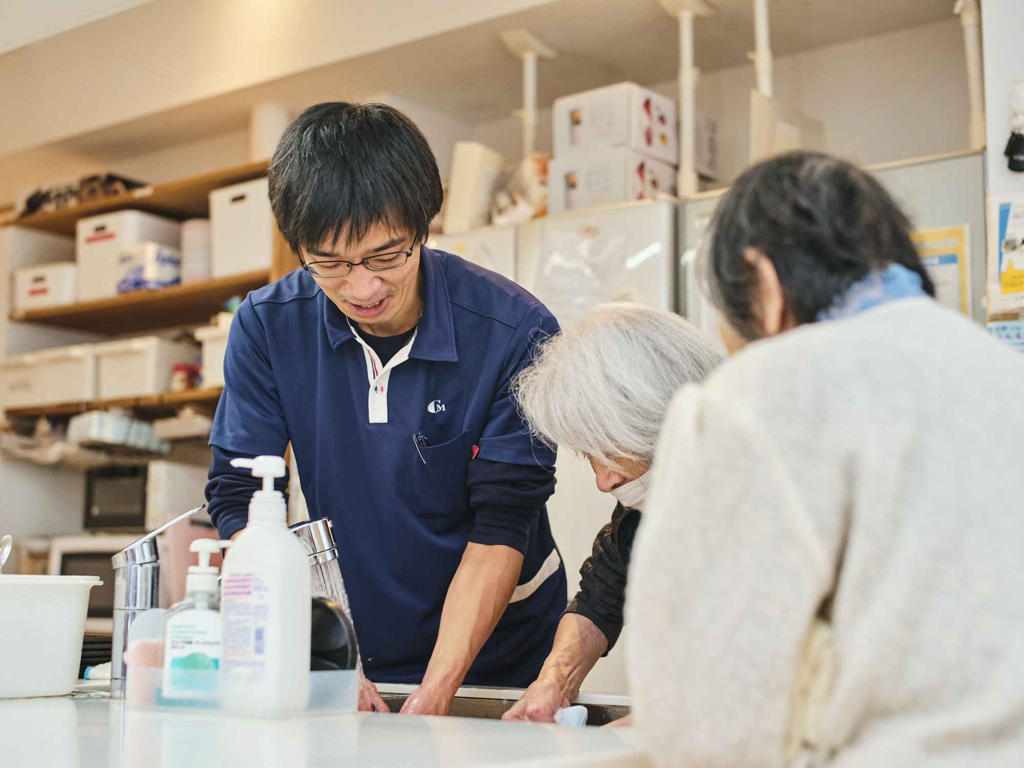 ご利用者様と二人と手を洗う篠原さんの写真