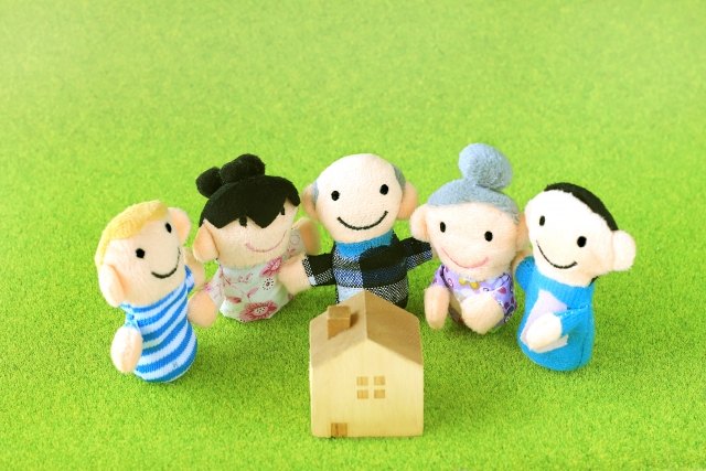 家族の人形が家を囲んでいる写真