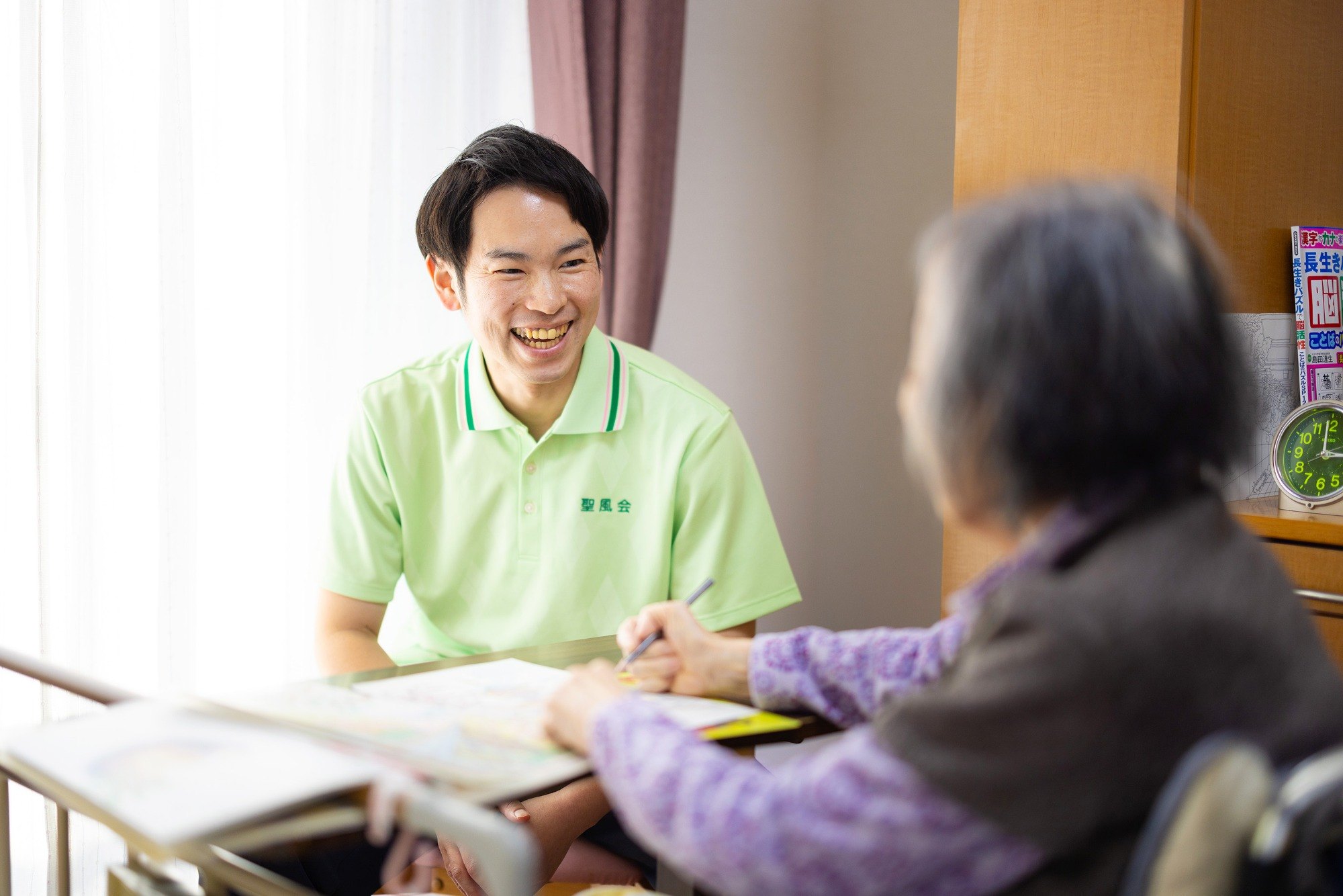 ご利用者様の女性と会話をする島崎さんの写真