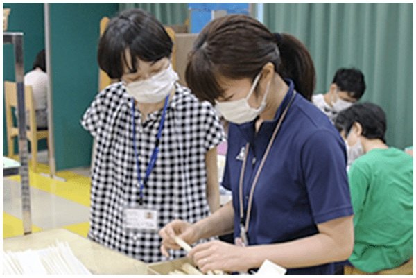 作業の見学をする秋山さんの写真