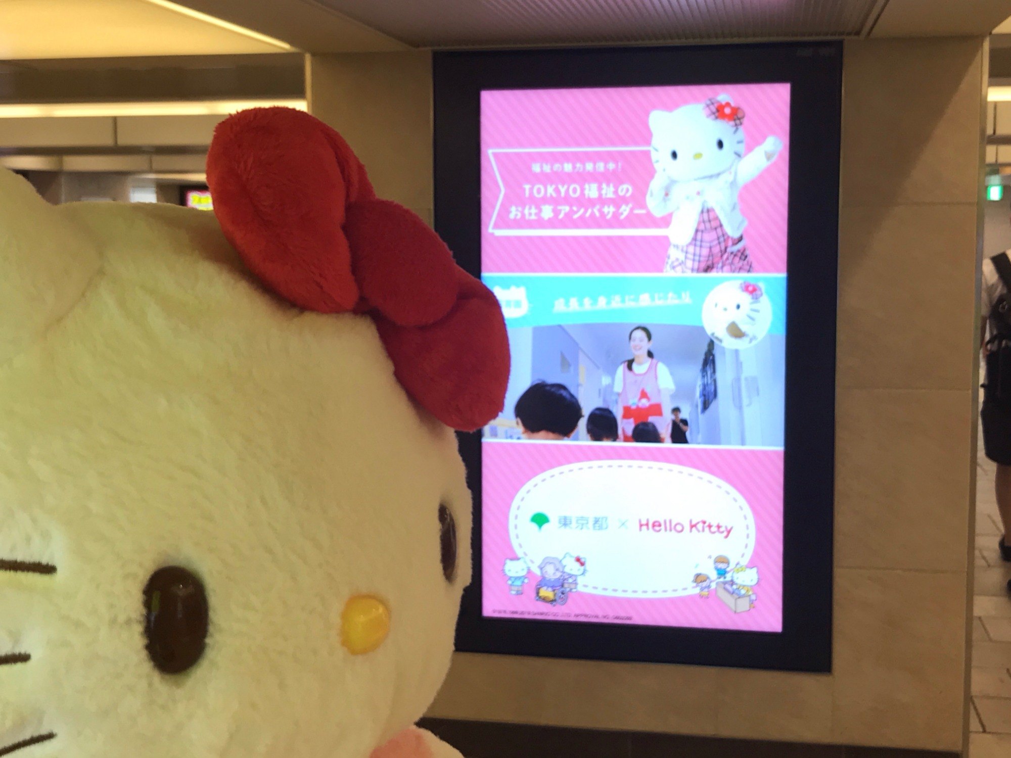 デジタルサイネージをみるキティちゃんの写真
